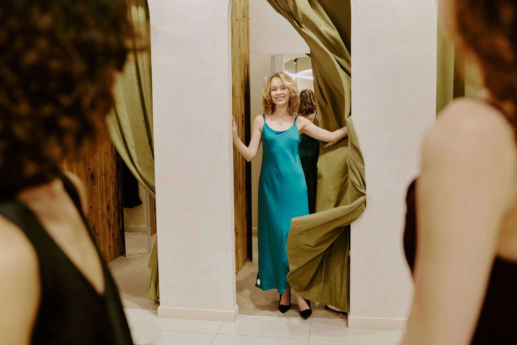 Women reviewing a silk dress in a fitting room