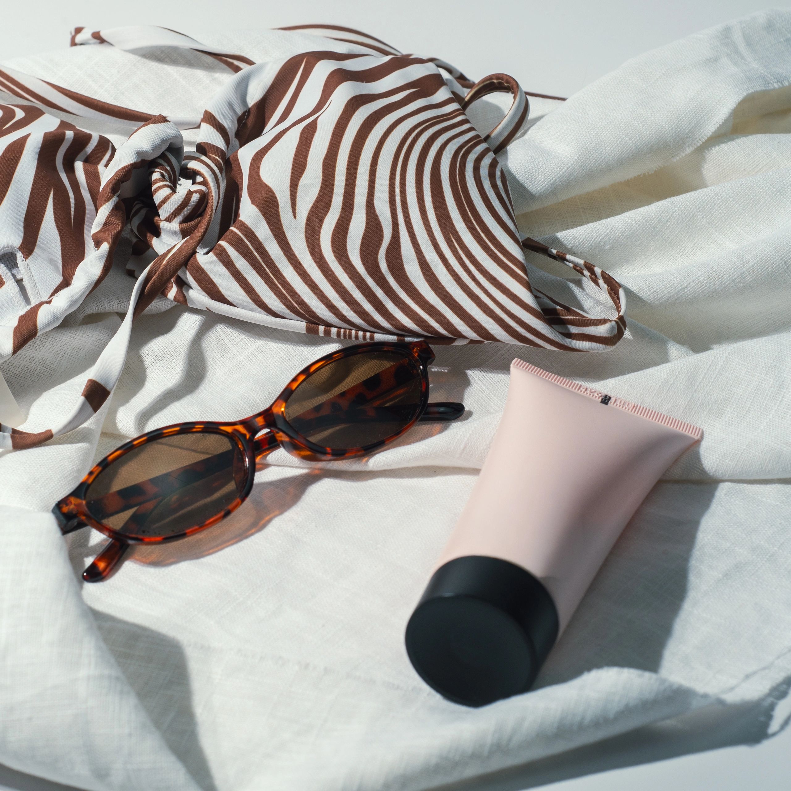 Beachwear accessories styled on white linen